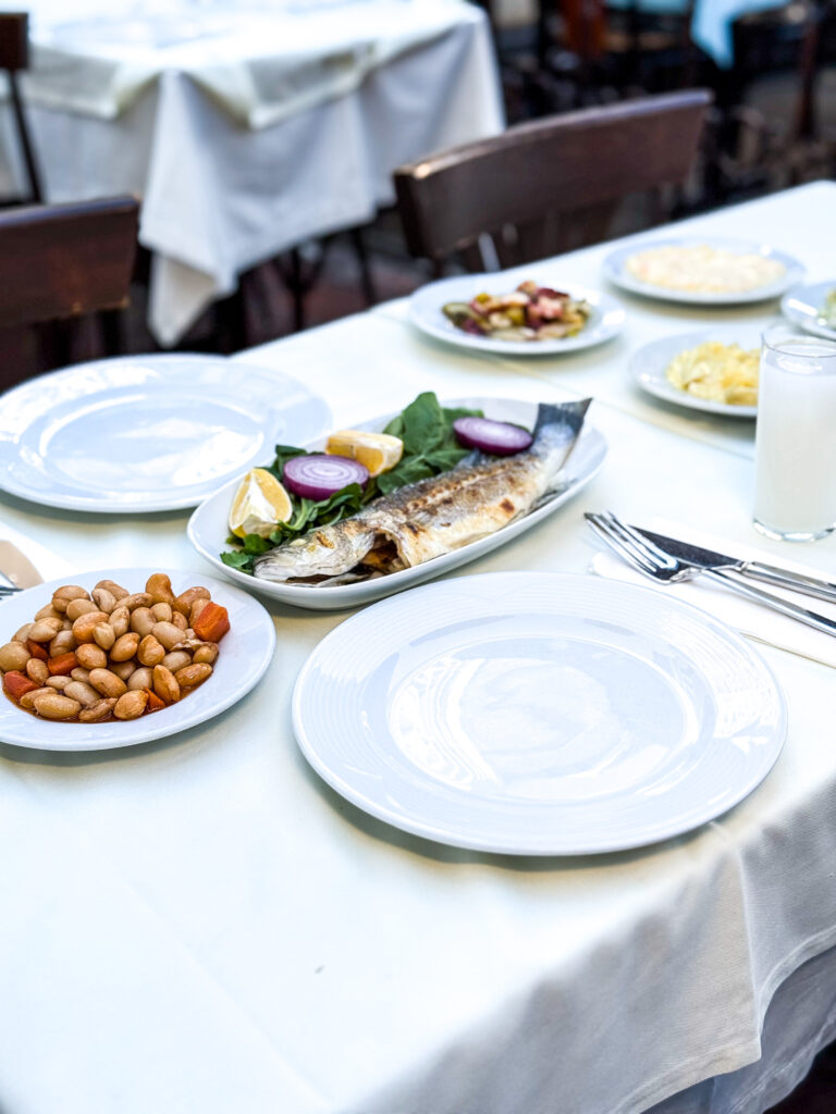 Kadir’in Yeri’nde Akşam Yemeği Beyoğlu atmosferi. Tarihi masada adaplı mezeler, rakı ve loş ışıkta sohbet anı.